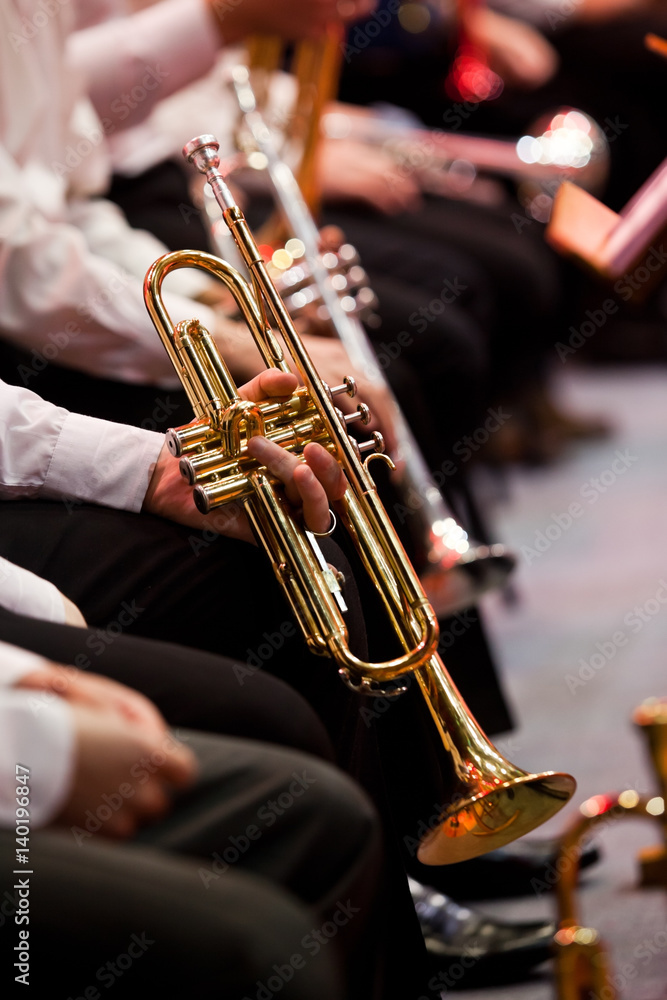 Obraz premium Hands of a musician holding a trumpet in an orchestra closeup