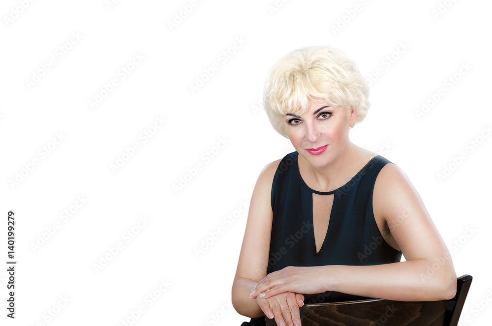 Woman in black cocktail dress looks at the camera expressly