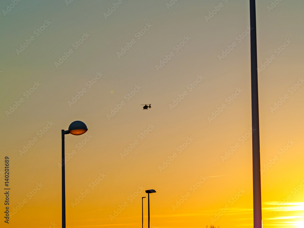 Sunset on a city and Streetlights and an helicopter
