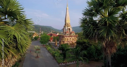 Drone Approaching Buddhist Temple Flying Between Palm Trees
