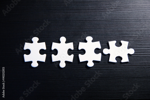 Vier Puzzleteile auf schwarzem Grund