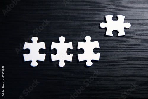Vier Puzzleteile auf schwarzem Grund