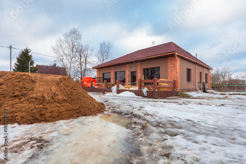 The modern house with terrace is under construction (remodel) and construction material for renovation are outside photo