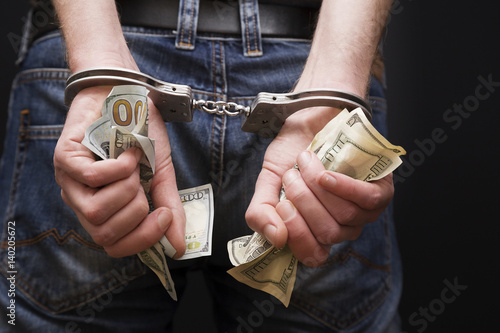 Man in handcuffs with money. photo