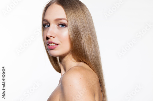 Cute young blonde model woman with long shiny hair loking at camera white background