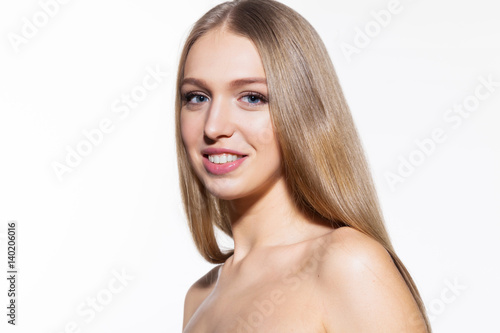 Blonde smiling model woman with long shiny hair loking at camera white background