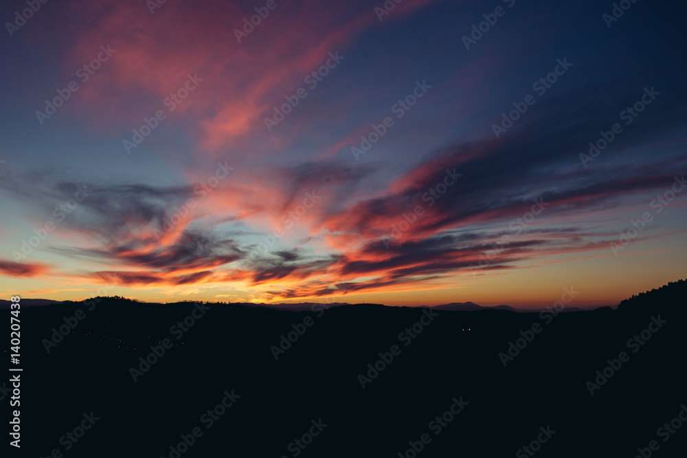 Beautiful red sunset over the field and forest Beautiful red sunset over the field and forest