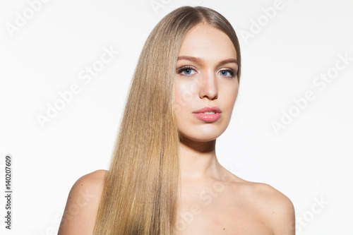 Beauty portrait of blonde model woman with long shiny hair and healthy skin looking at camera on white background