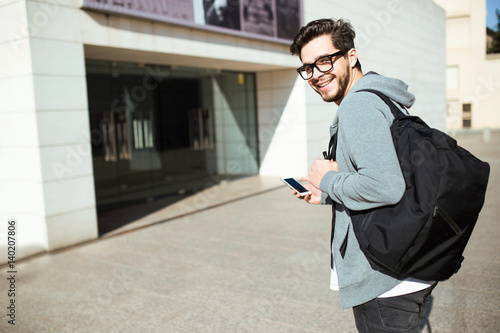 Handsome young man using his mobile phone in the street.