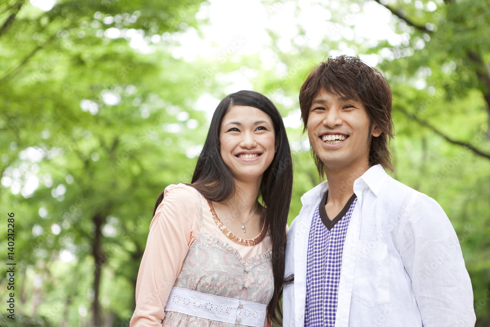 Young couple standing side by side smiling Young couple standing side by side smiling