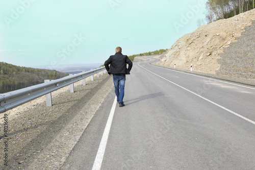Man walking on a mountain road to his dream