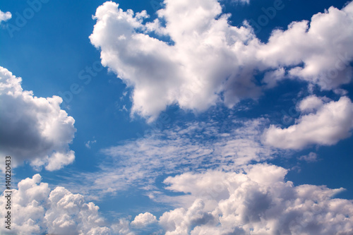 White curly clouds in a blue sky. Sky background