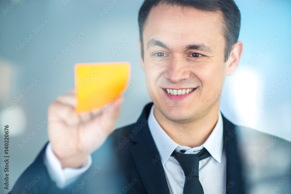 The businessman stand near a sticker on the glass The businessman stand near a sticker on the glass