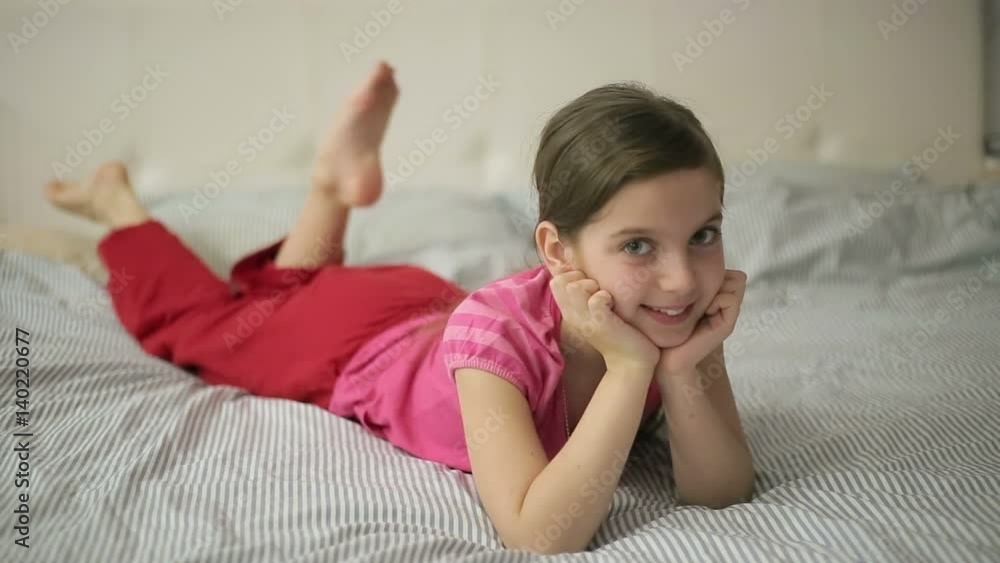 Girl lying on the bed moves feet StockVideo Adobe Stock