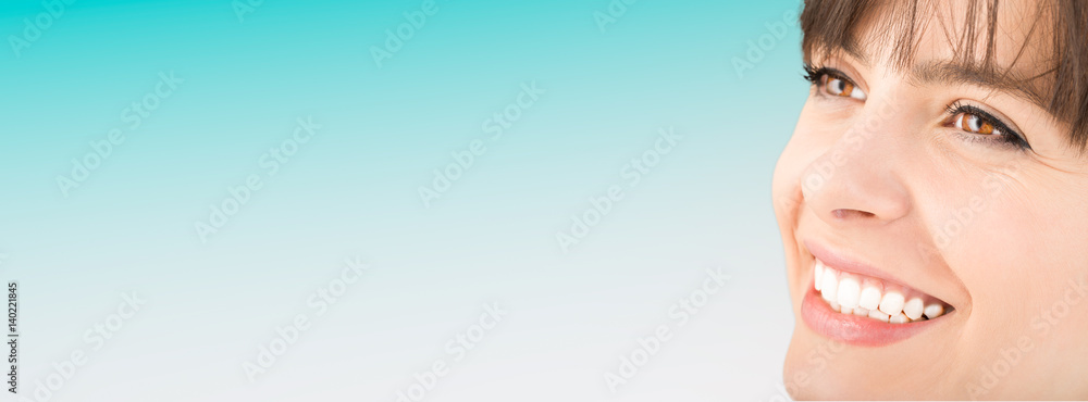 Fototapeta premium Beautiful smile young woman. White teeth on the master plan.