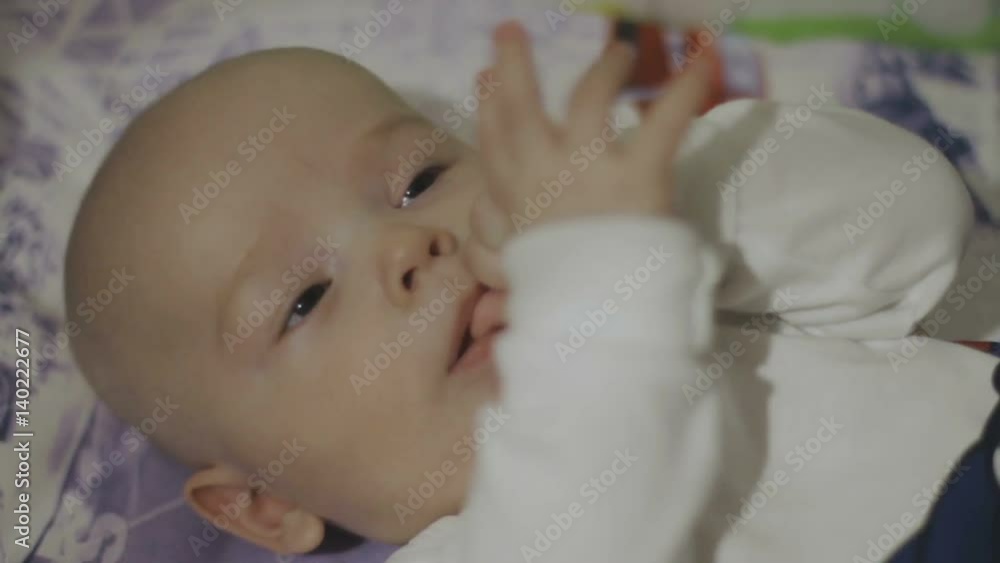 Happy newborn baby yawns closeup in white bed Happy newborn baby yawns closeup in white bed