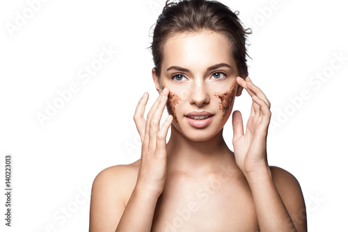 Fotografi Portrait of a young woman with a coffee scrub on her face doing peeling skin iso