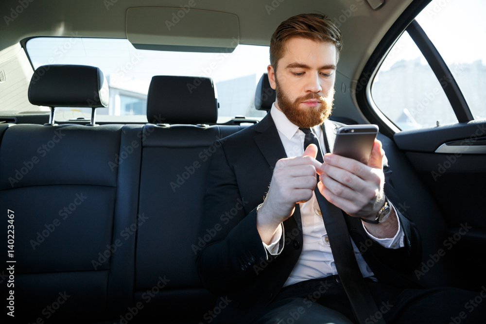 Handsome bearded business man in suit using mobile phone Handsome bearded business man in suit using mobile phone