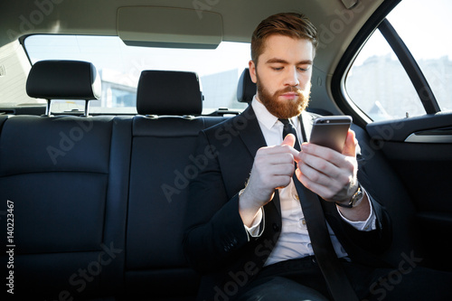 Handsome bearded business man in suit using mobile phone © Drobot Dean