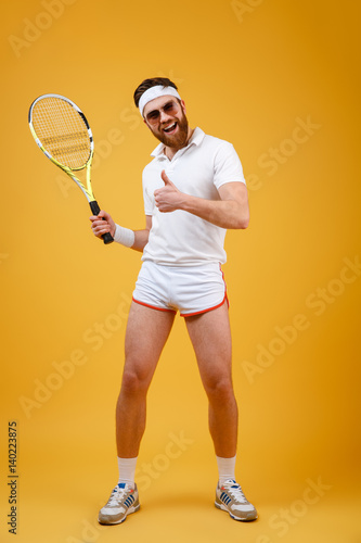 Vertical image of sportsman with tennis racquet showing thumb up © Drobot Dean