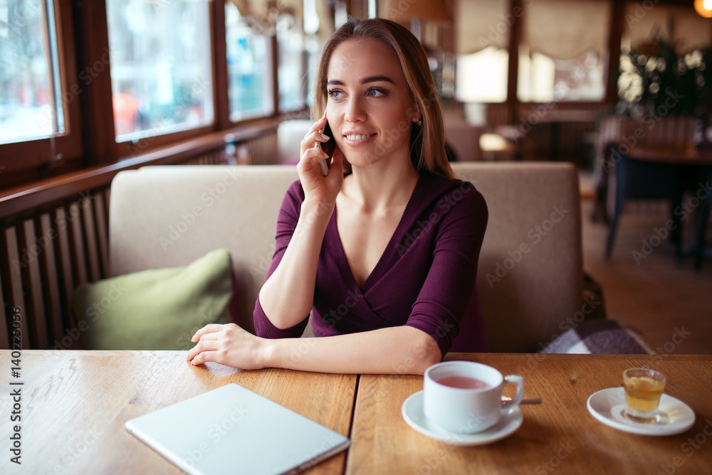 Woman using phone in cafe. Woman using phone in cafe.