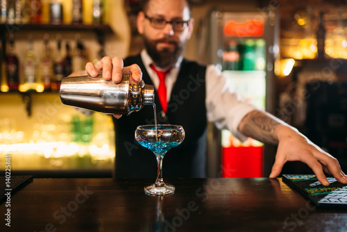 Bartender with shaker making alcohol cocktail