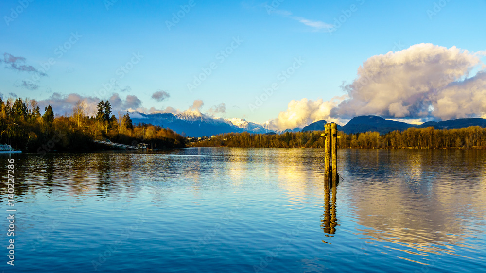 Naklejka premium Sunset over the Fraser River near Fort Langley in the middle of winter with the snow covered Coastal Mountains in the background
