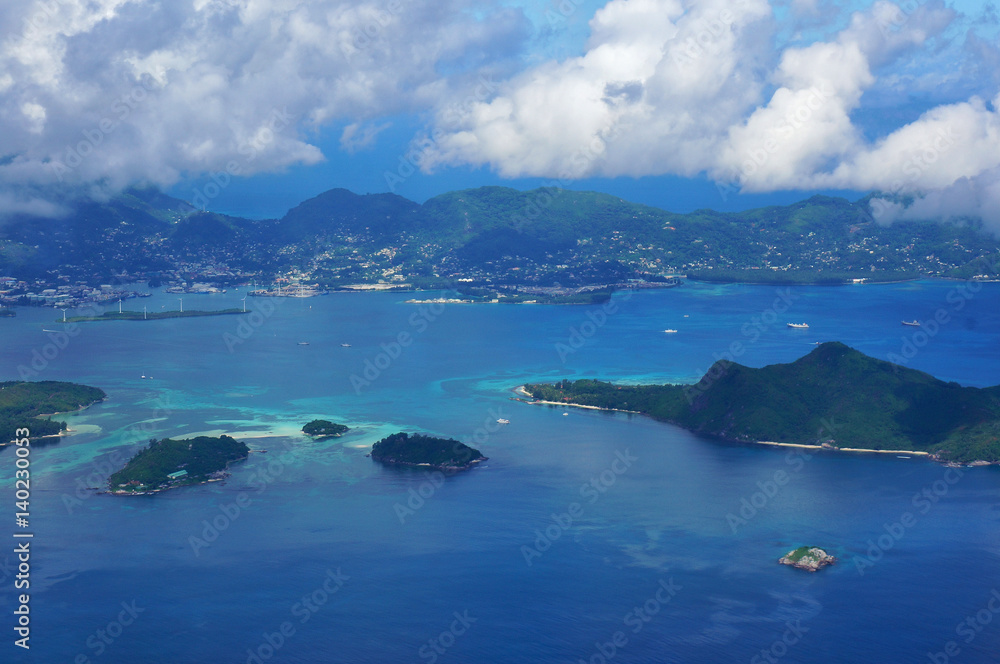 Scenic aerial landscape of the Seychelles Islands with azure ocean water, blue sky and white clouds. Idyllic scenery of seaside resort. Exotic travel destination for holiday and vacation