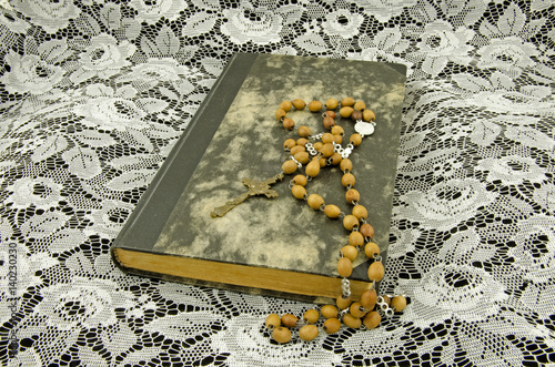 Still life with a book and a rosary on a background of lace