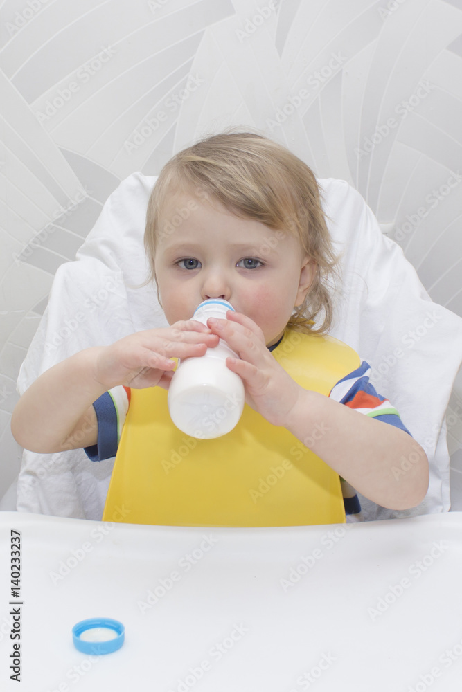little boy is drinking milk. holding glass of milk little boy is drinking milk. holding glass of milk