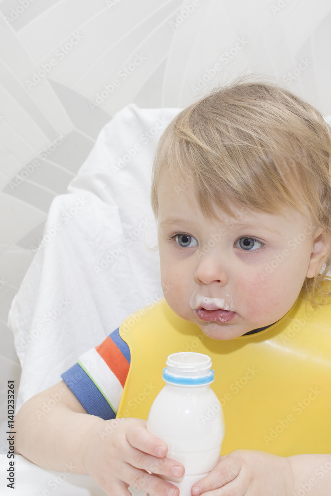 little boy is drinking milk. holding glass of milk little boy is drinking milk. holding glass of milk