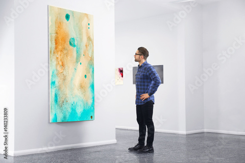 Young man in modern art gallery photo