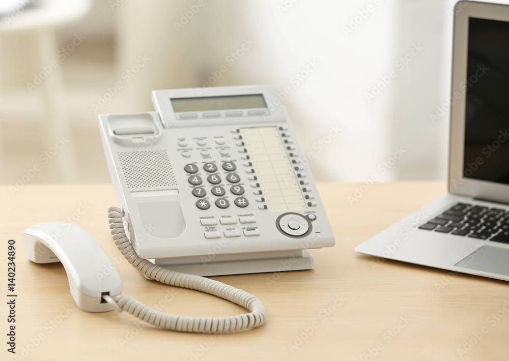 Telephone with picked up receiver on wooden table in office Telephone with picked up receiver on wooden table in office