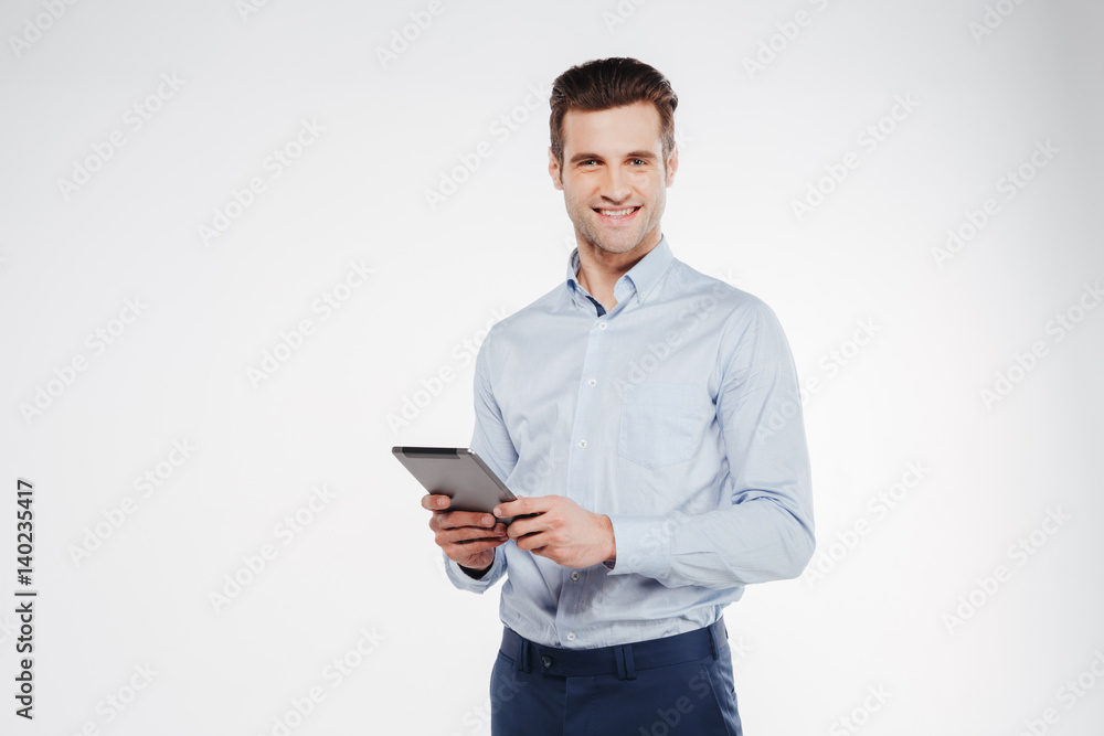 Smiling business man holding tablet computer Photos | Adobe Stock