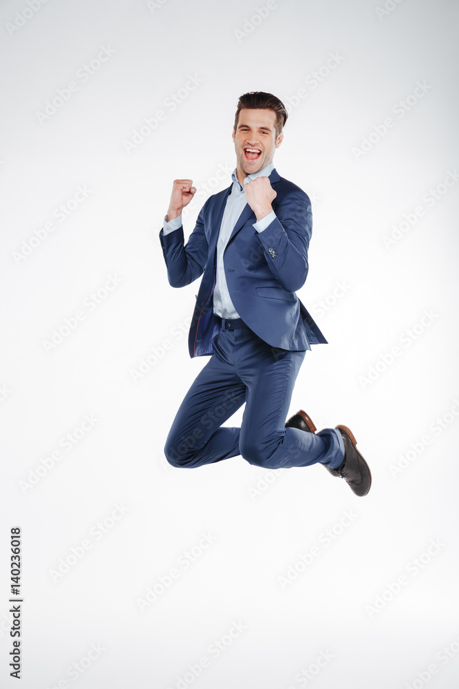 Full length portrait of happy business man jumping in studio Full length portrait of happy business man jumping in studio