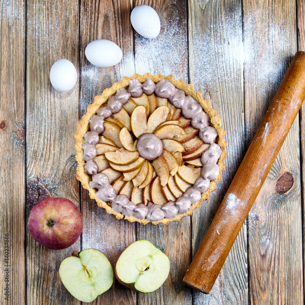 Beautiful classic apple tart with meringue. American / French pie with apples and whipped egg whites. Chocolate meringue on the cake. Baking from short pastry. Kitchen table in flour. Beautiful classic apple tart with meringue. American / French pie with apples and whipped egg whites. Chocolate meringue on the cake. Baking from short pastry. Kitchen table in flour.