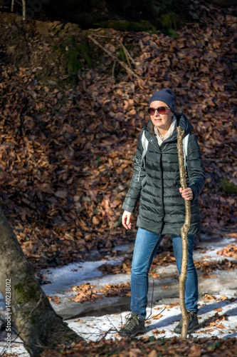 Adult woman hiking through the woods in early spring