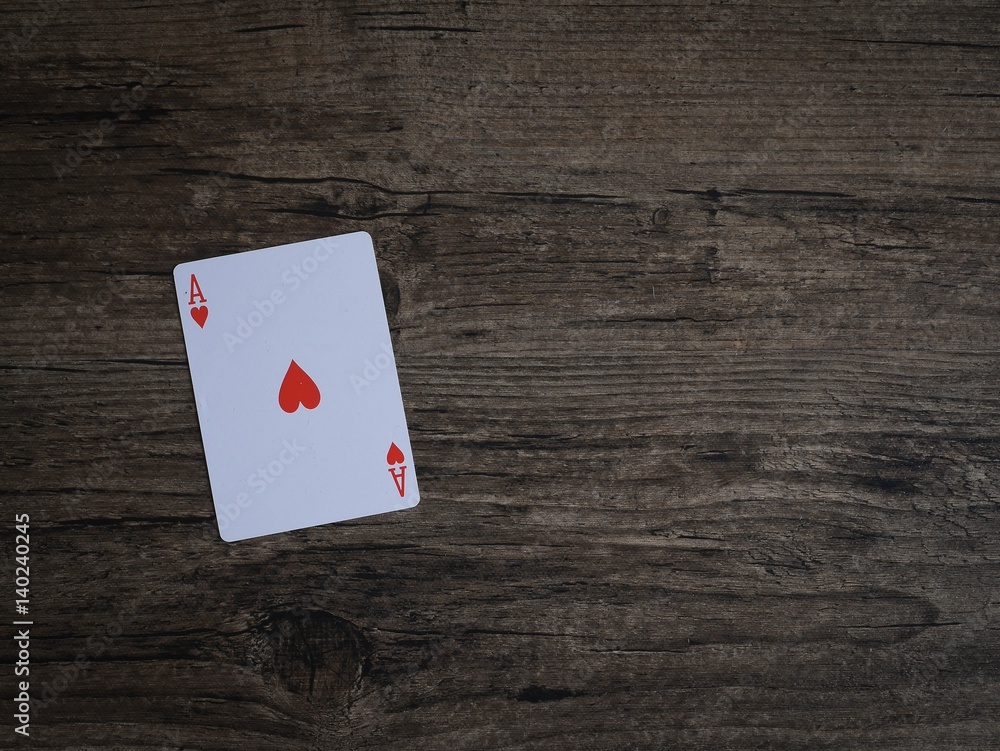 Casino play card Ace red heart on wooden vintage dark brown grunge texture on top able plan view with copy space