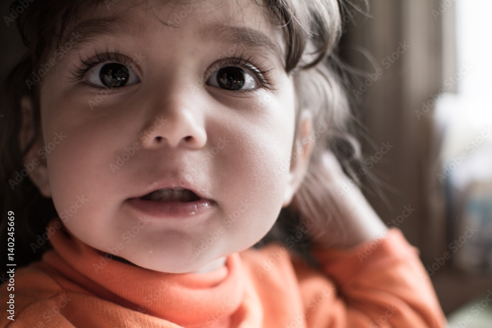 Child girl sitting at a table and gesturing with his hands.
Child girl sitting at a table and gesturing with his hands.