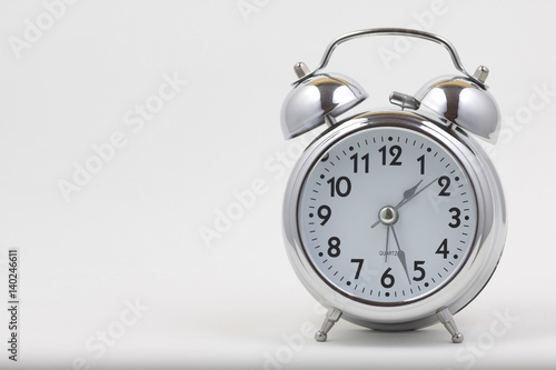 Nice old vintage chrome metal twin bell alarm clock on white background with copy space. 