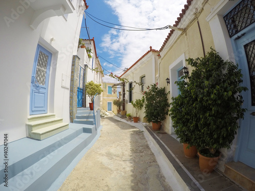 Fototapeta Naklejka Na Ścianę i Meble -  POROS, GREECE - JUNE 08, 2016: photo of cozy beautiful street full of plants and colours in the sunny Greece