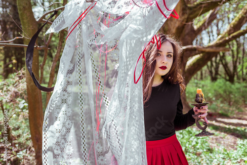 witch in the woods with a candle photo