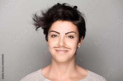 Smiling Woman with Drawn Mustaches on Gray Background