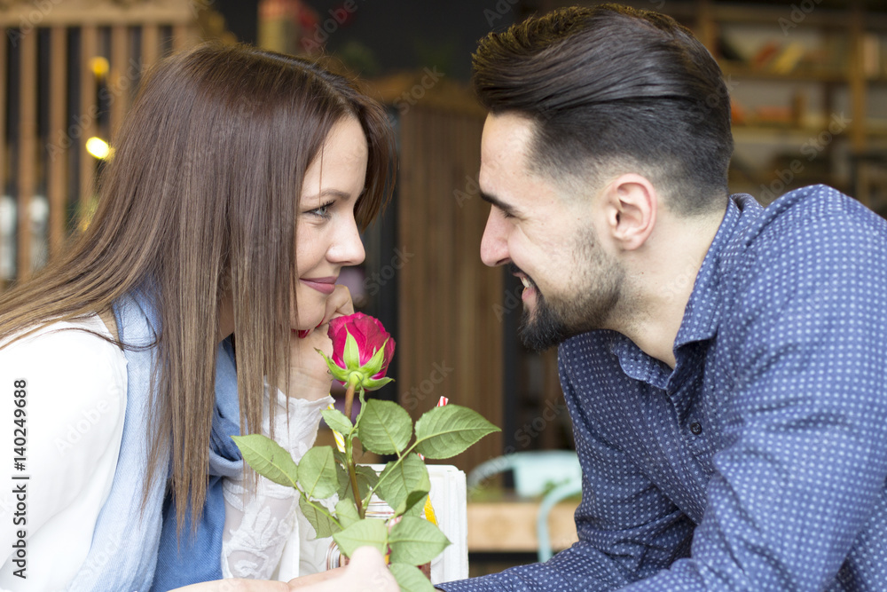 Young couple at cafe with red rose Young couple at cafe with red rose