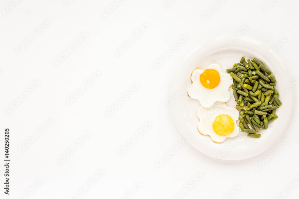 Healthy breakfast. Fried eggs, green beans on white background. Flat lay Healthy breakfast. Fried eggs, green beans on white background. Flat lay