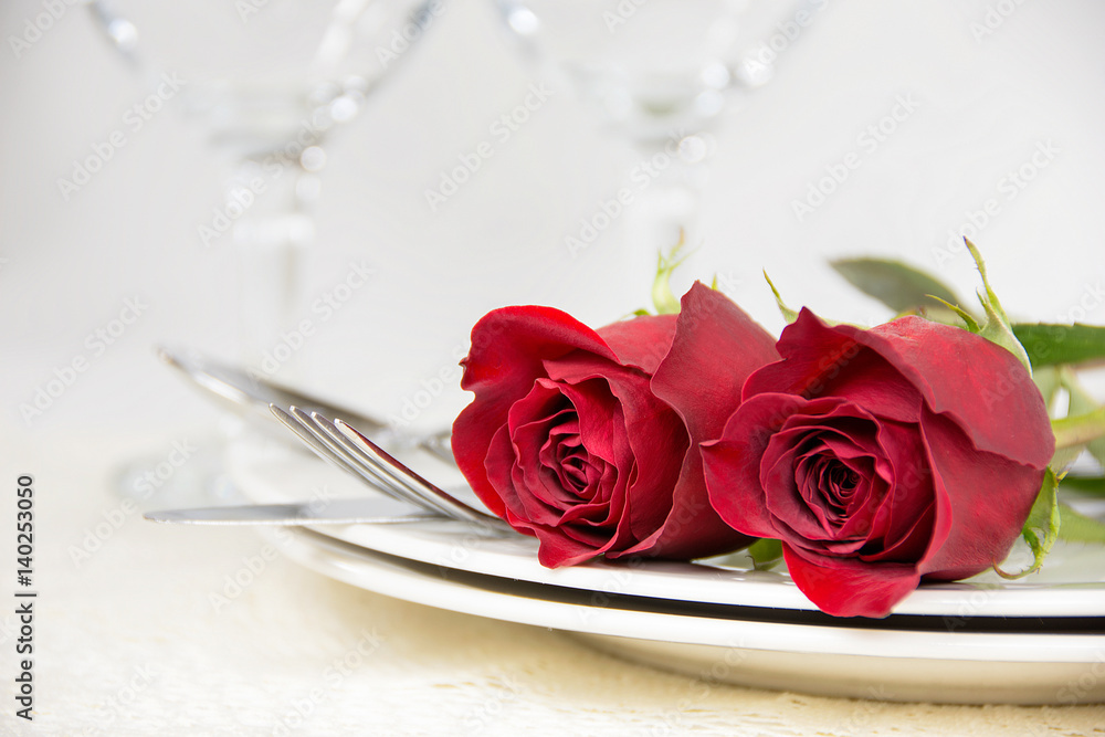red roses on plate with silverware for romantic dinner red roses on plate with silverware for romantic dinner