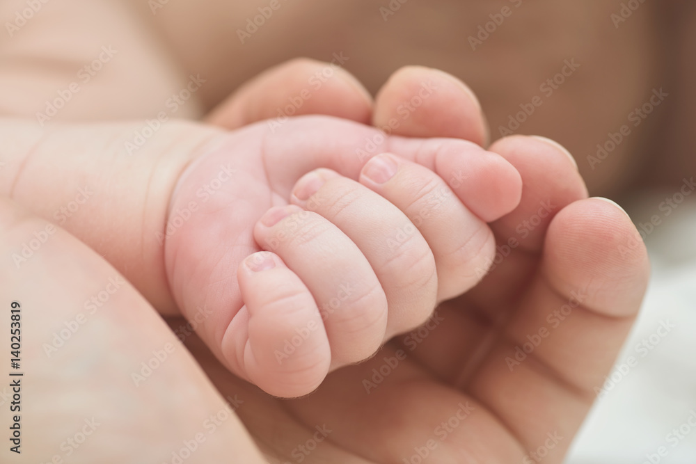 A parent holding the hand of a newborn baby A parent holding the hand of a newborn baby
