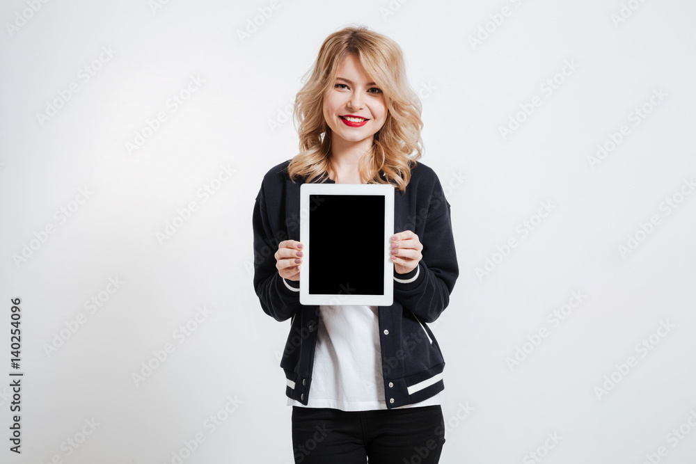 Young lady showing display of tablet computer to camera. Young lady showing display of tablet computer to camera.