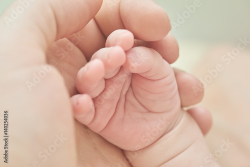A parent holding the hand of a newborn baby © elmowski