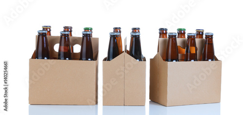 Schilderij op canvas Six packs of glass bottled beer in generic brown cardboard carriers on white bac